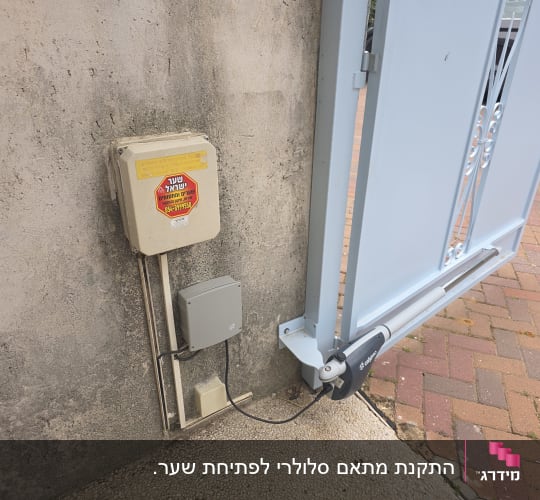 שער חשמלי עם מנוע ומערכת בקרה על קיר